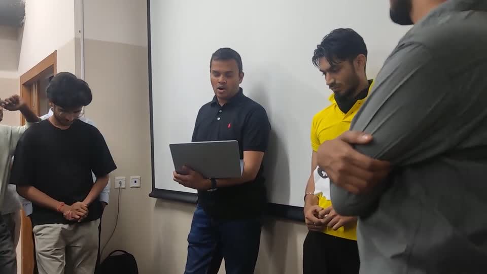 Lakshmi reading feedback from a laptop, with Fuzlan standing beside him.